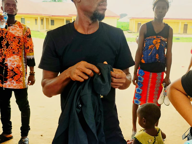 A volunteer handing out donated clothing during the Uyo outreach