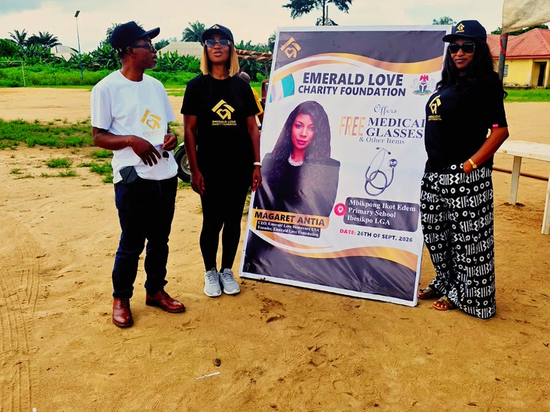 Team members beside the Emerald Love Charity Foundation outreach banner