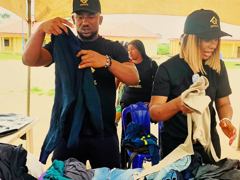 Volunteers presenting donated clothing to residents during the Uyo outreach